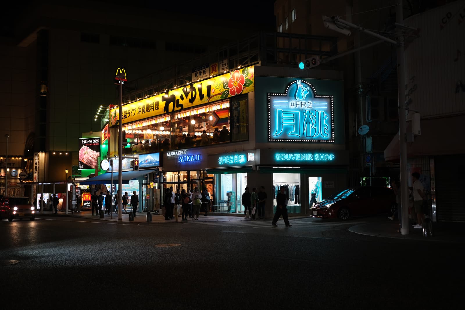 Neon shopfronts on a Naha street at night